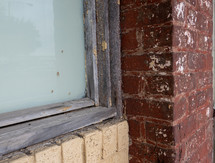 corner of window and brick wall, weathered building façade detail