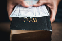One hundred dollar bills and a Bible