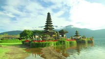 Beautiful balinese temple by the lake with colorful flowers and clear skies 4K