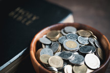 Coins next to a Bible