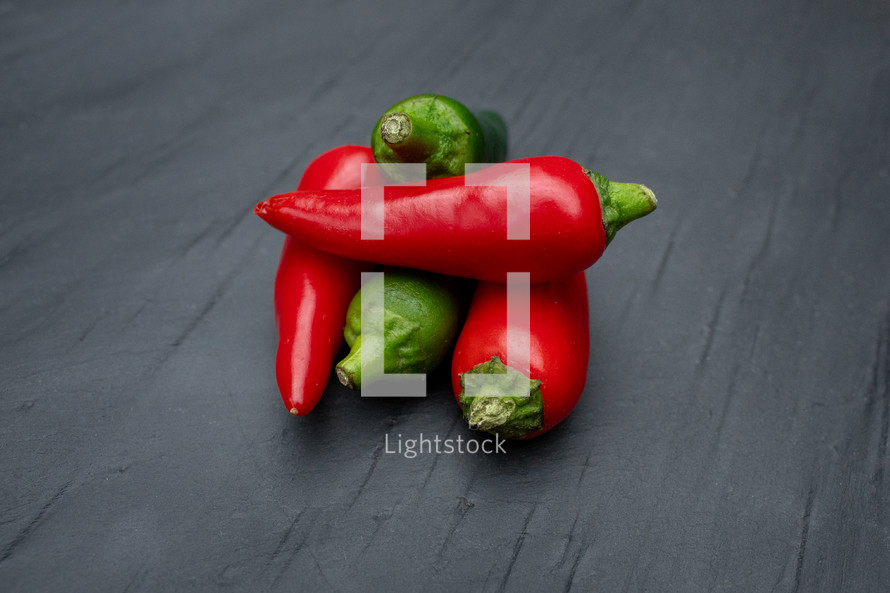 Red and Green Chilies Stacked on a Slate