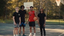 Portrait of smiling young men after playing basketball on a sunny day