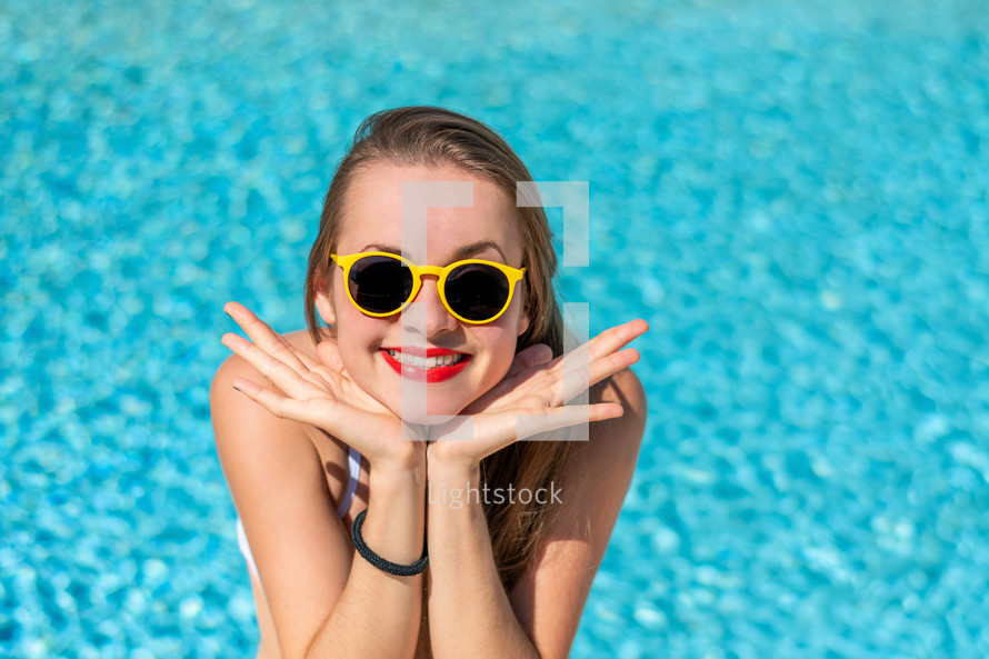 a teen girl by a swimming pool 