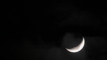 In night sky seen crescent and passing clouds