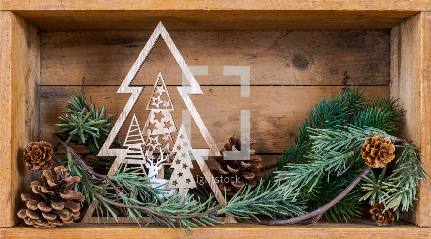 wooden box with pine cones and greenery at Christmas 