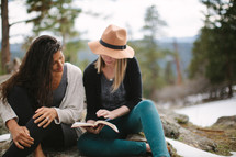 friends reading a Bible together outdoors 