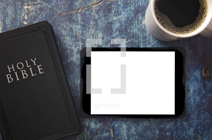 tablet, Bible and coffee cup on a blue grunge background 
