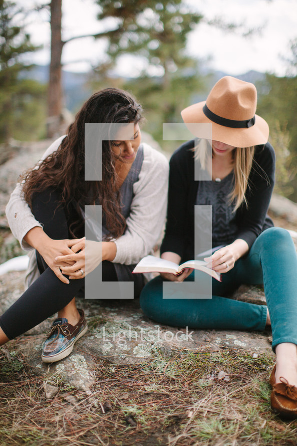 friends reading a Bible outdoors 