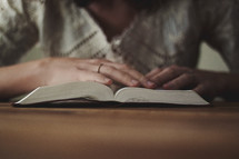a woman sitting and reading a Bible 