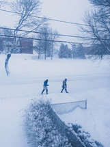 people walking in snow under power lines 