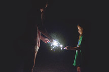 mother and daughter lighting sparklers 