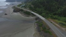 Aerial view of cars driving on a highway alongside the ocean shore.