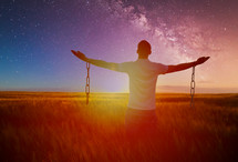 man with outstretched arms and broken chains 