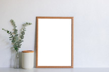 blank frame and vase of eucalyptus 
