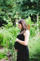 side profile of a pregnant woman holding her belly 