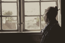 an elderly woman looking out a window 