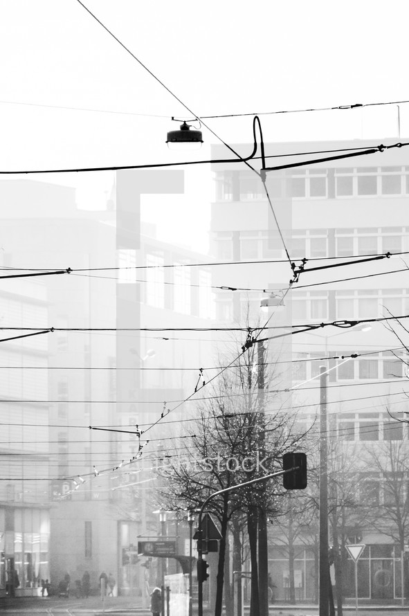 power lines over a city in fog 