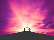 silhouttes of crosses against a pink background 