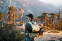 a man backpacking through a mountain forest 