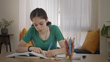 Teenage girl sitting at home preparing homework for school