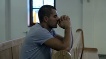 a man kneeling in prayer in church 