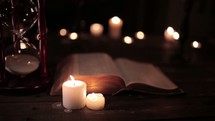 votive candles and flipping pages of a Bible 