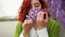 Woman smelling wisteria.
