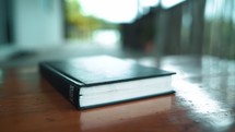 Close up Bible on wooden table in the morning.