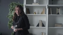 a woman in a home office drinking coffee 