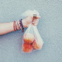 a hand holding a bag of peaches 