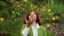 Woman smiling and throwing a lemon into the air.