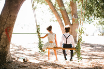 children sitting on a swing 