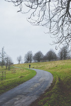 a man walking on a rural road through Dyrham Park