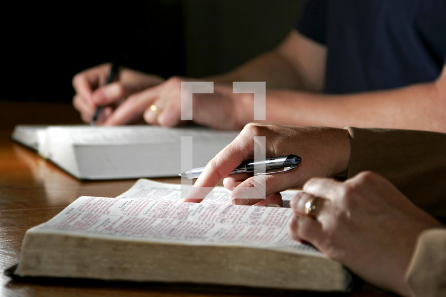 A couple studies the Holy Bible together - Can be during devotional time or with a bible study group.