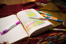 highlighters and pens on an open Bible 