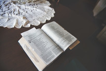 open Bible and lace cloth on a table 