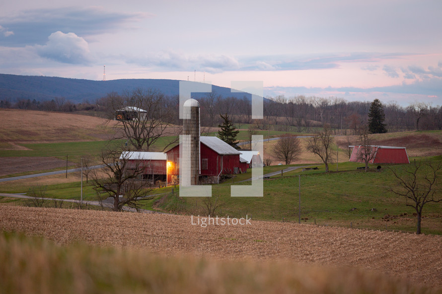 View of red barn and silo near crop field on Pennsylvania farm