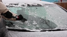 Man Scraping Ice Off Frozen Windshield Of A Car During Winter. close up