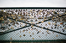 A chain link fence on a bridge covered in locks