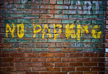 "No Parking" painted on brick wall