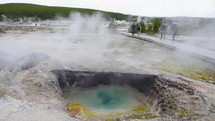 Tourists walking near Boiling hot water in Spring, Yellowstone National Park.