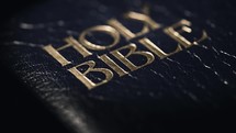 Light reveal to a dark and moody cover of The Holy Bible.