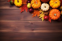 Autumn background with pumpkins and leaves on wooden board. Space for text