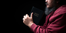 Man holding Bible in prayer