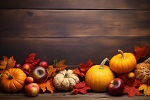 Autumn still life with pumpkins, apples and leaves on wooden background