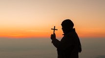 Silhouette of man praying at sunset