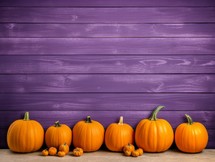 Pumpkins on wooden table and purple wooden wall. Space for text