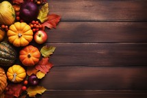 Autumn composition with pumpkins, apples and berries on wooden background
