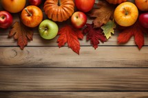 Autumn background with pumpkins, apples and leaves on wooden table