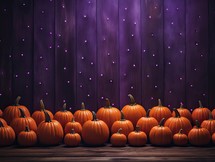 Halloween background with pumpkins on wooden planks and purple lights